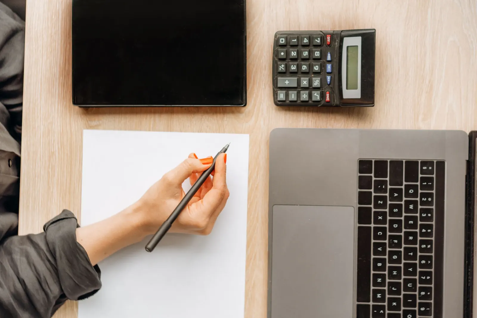 Desk with a laptop, a calculator and notes while a budget is planned